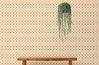 Wall mural with orange and teal atomic patterns behind a wooden bench and plant.