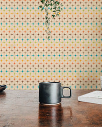Atomic pattern mural on a textured wall with a black coffee mug.