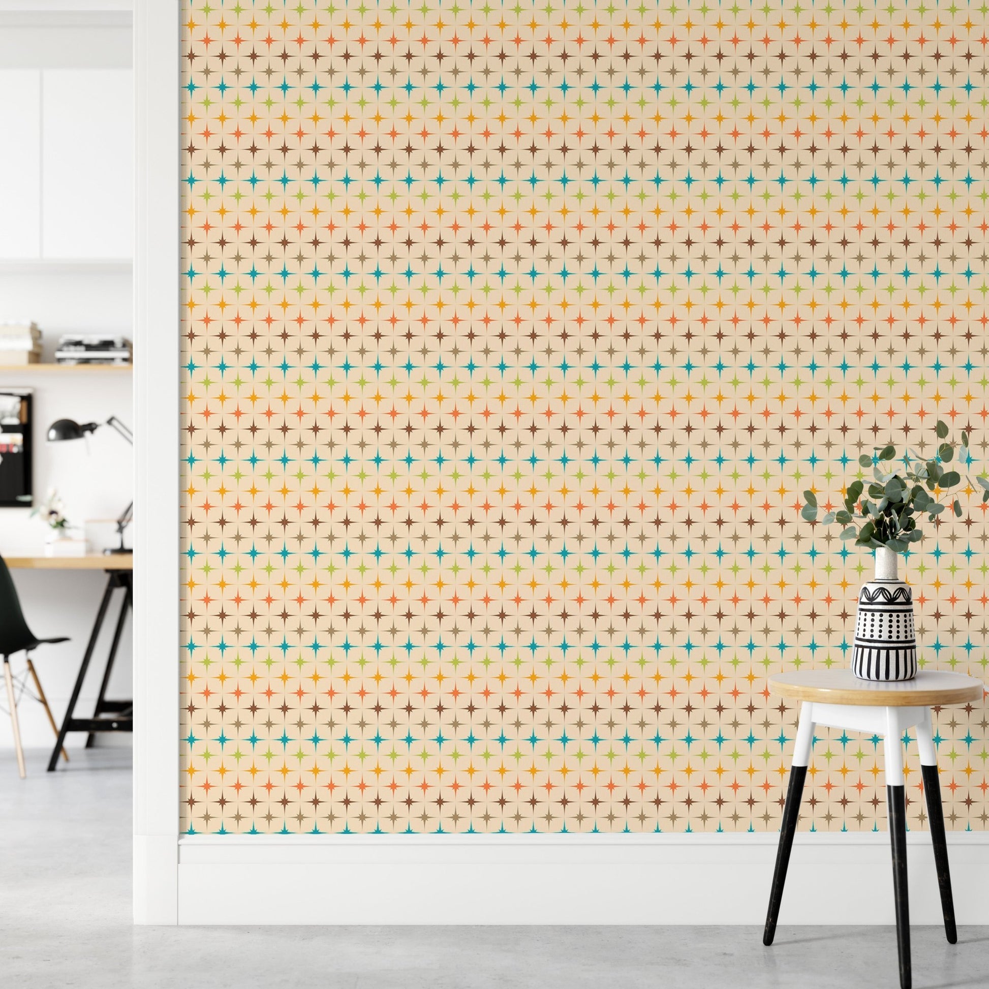 Retro geometric wall mural with teal and orange shapes near a minimalist stool.