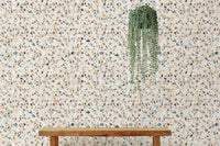 Minimalist wooden bench with hanging plants against a stone wallpaper.