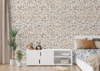 Children's bedroom featuring white furniture and colorful mosaic wallpaper.
