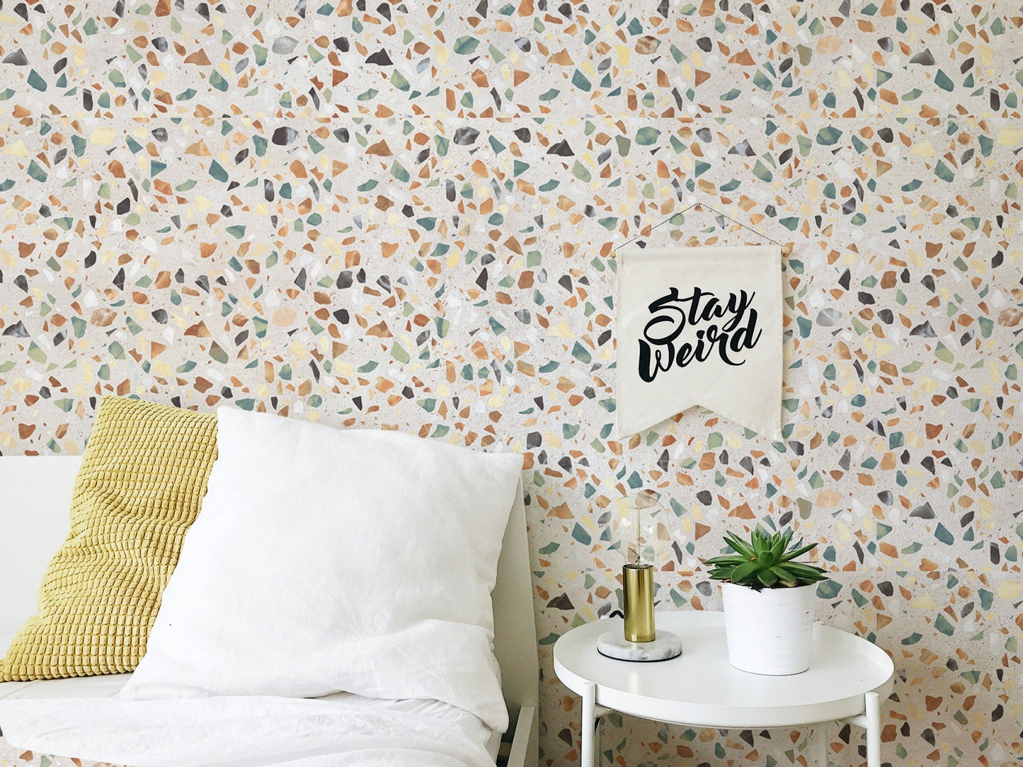 Bedroom wall decor with white bedding and terrazzo pattern wallpaper