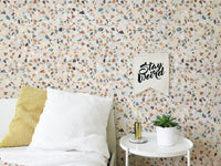 Bedroom wall decor with white bedding and terrazzo pattern wallpaper