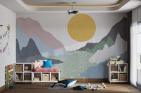 Minimalist mountain wall mural with mustard yellow sun and green fields.