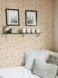 Bedroom corner with framed art and white cushions against a pastel background wall mural