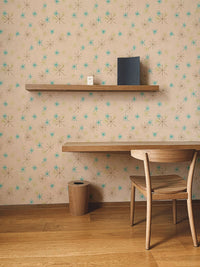 Home office setup with a floating wooden shelf on a colorful snow fleck wall mural.