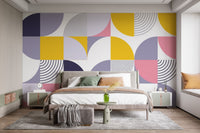 Modern bedroom with geometric pattern wallpaper in yellow, pink, and grey tones.