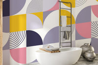 Geometric wallpaper with semi-circle patterns behind a white bathtub in a bathroom.
