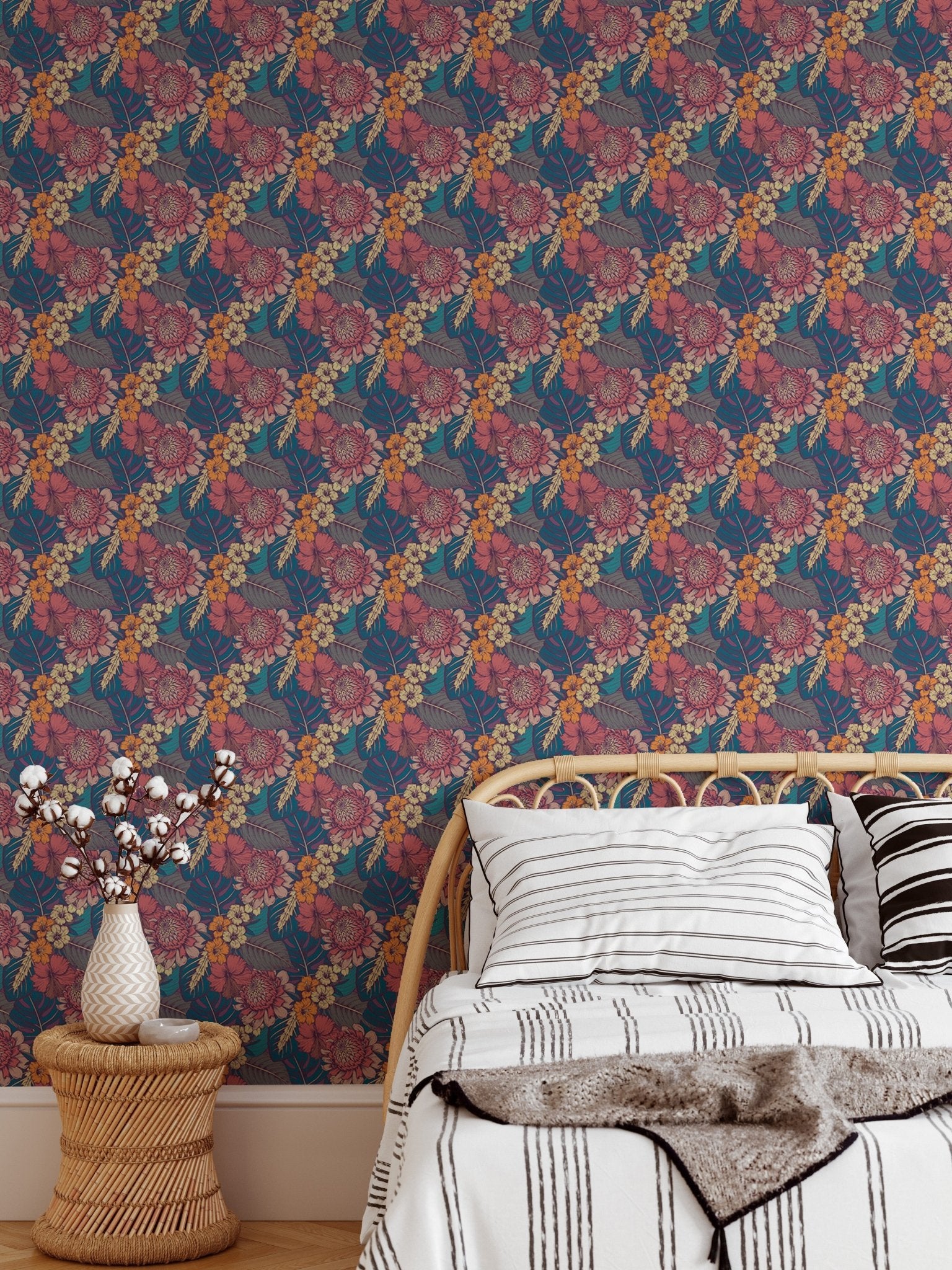 Dark flowers wallpaper in a bedroom behind a bed with white and grey linen.