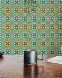 Intricate art pattern wall mural seen behind a dark mug on a wooden desk.