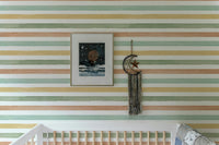 Colorful pattern wallpaper in a nursery with a framed picture and wall hanging