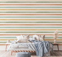 Multi-colour pastel wallpaper mural behind a large bed with neutral pillows