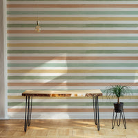 Minimalist workspace featuring green and orange striped wallpaper and wooden desk