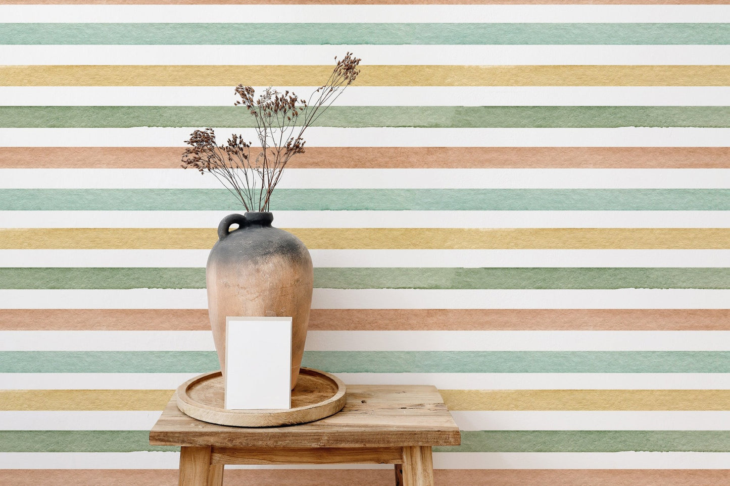 Pale green and peach striped wallpaper behind a wooden stool and ceramic vase