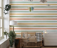 Nursery room wallpaper with horizontal stripes near a wooden cot and lamp