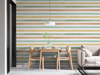 Horizontal striped wallpaper behind a wooden dining table and grey sofa