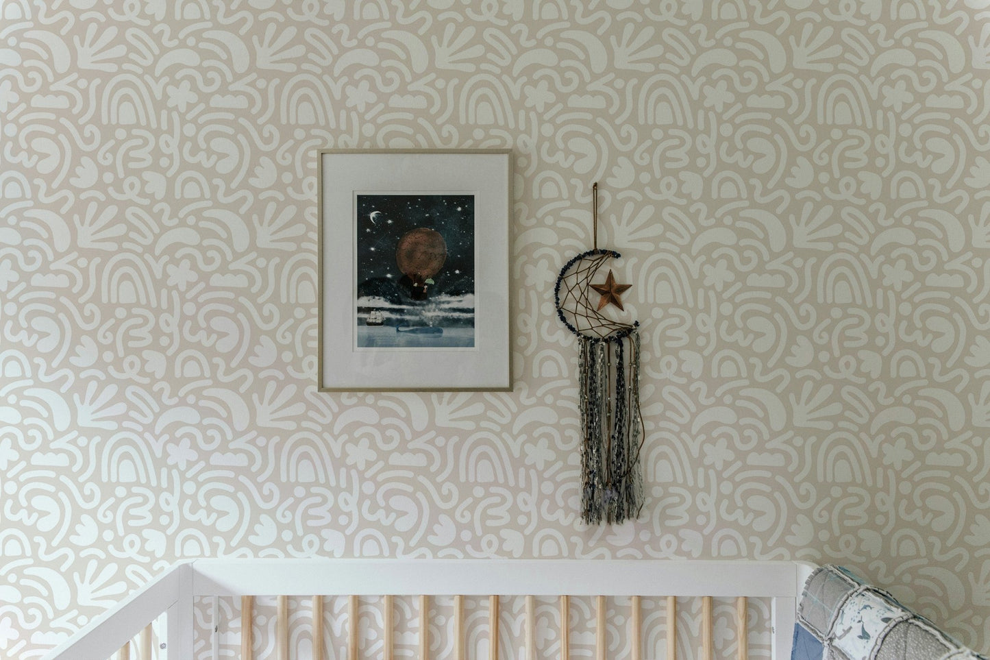 Abstract Wallpaper in a nursery setting featuring a framed picture and white crib.