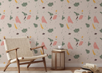 Geometric terrazzo wallpaper behind a light wood chair and small wooden side table.