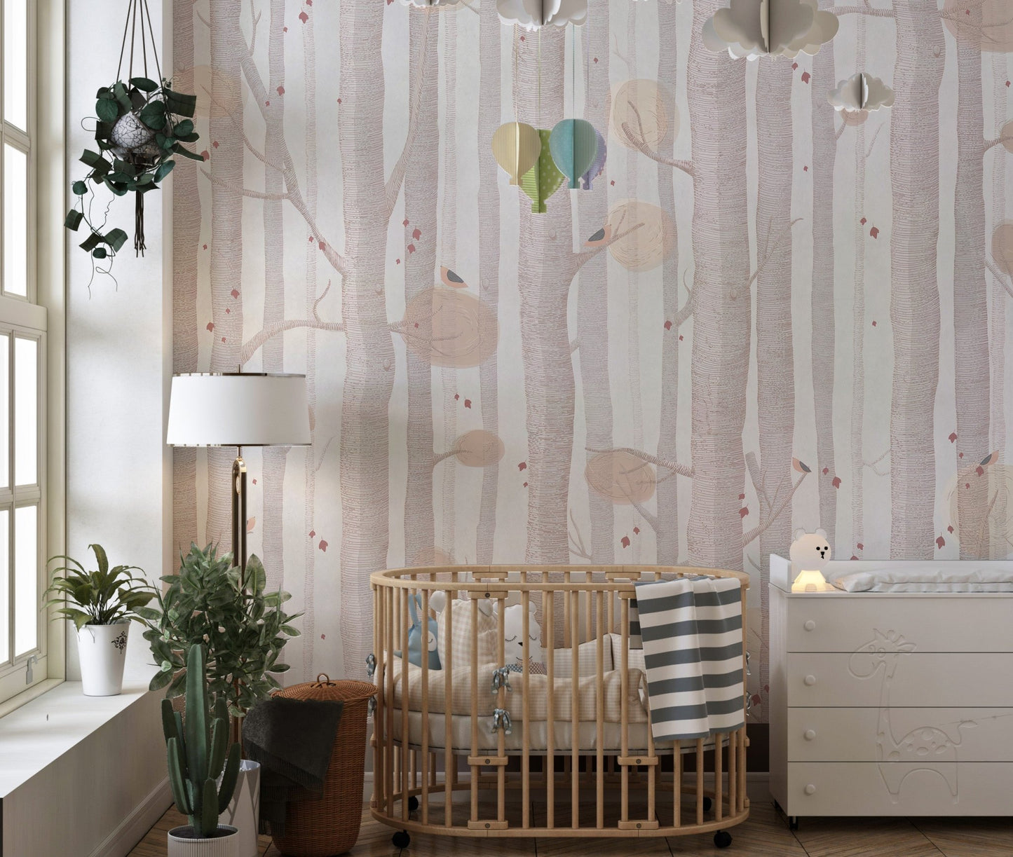 Subtle tree branch wall mural in a nursery with a wooden crib.