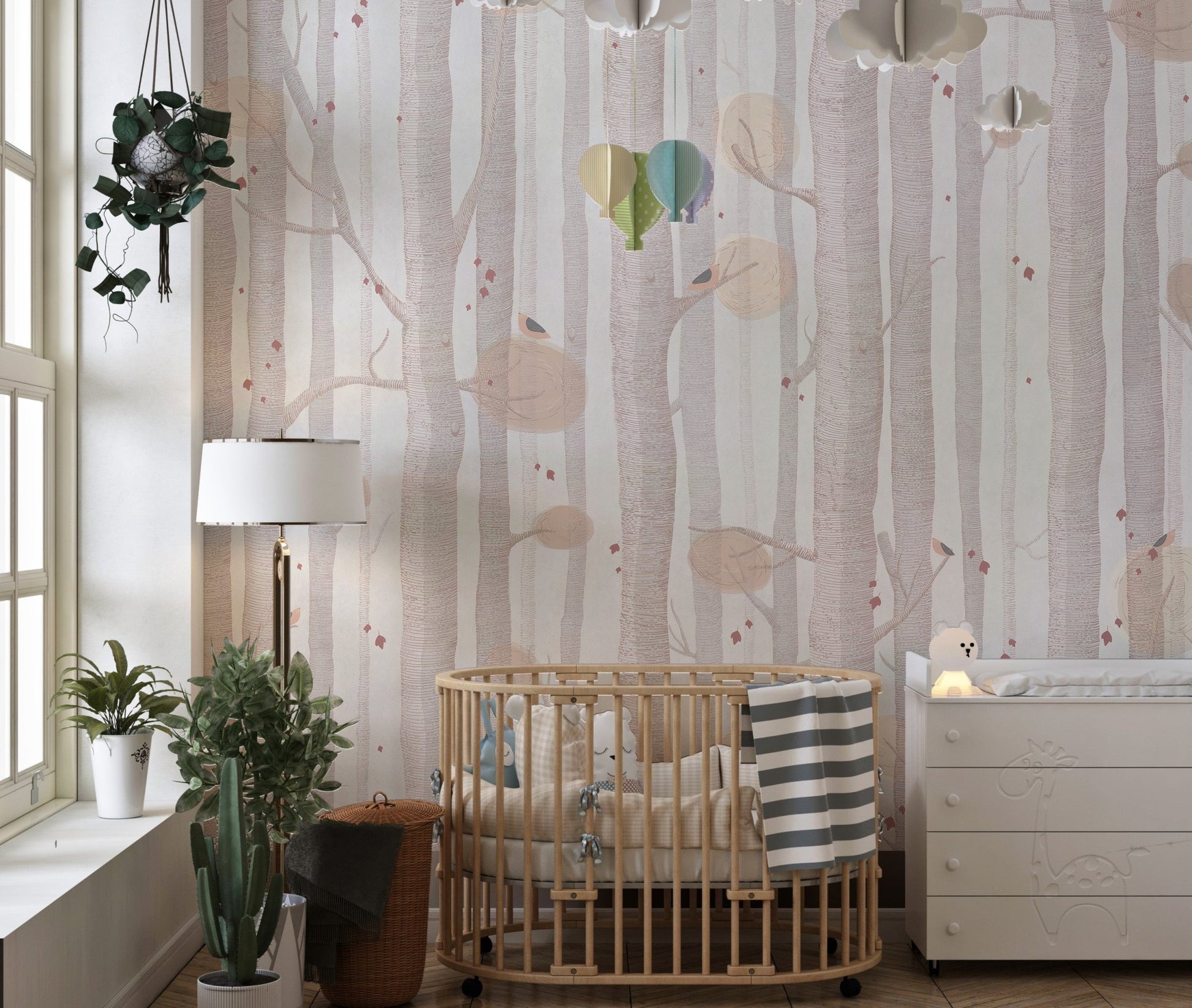 Subtle tree branch wall mural in a nursery with a wooden crib.