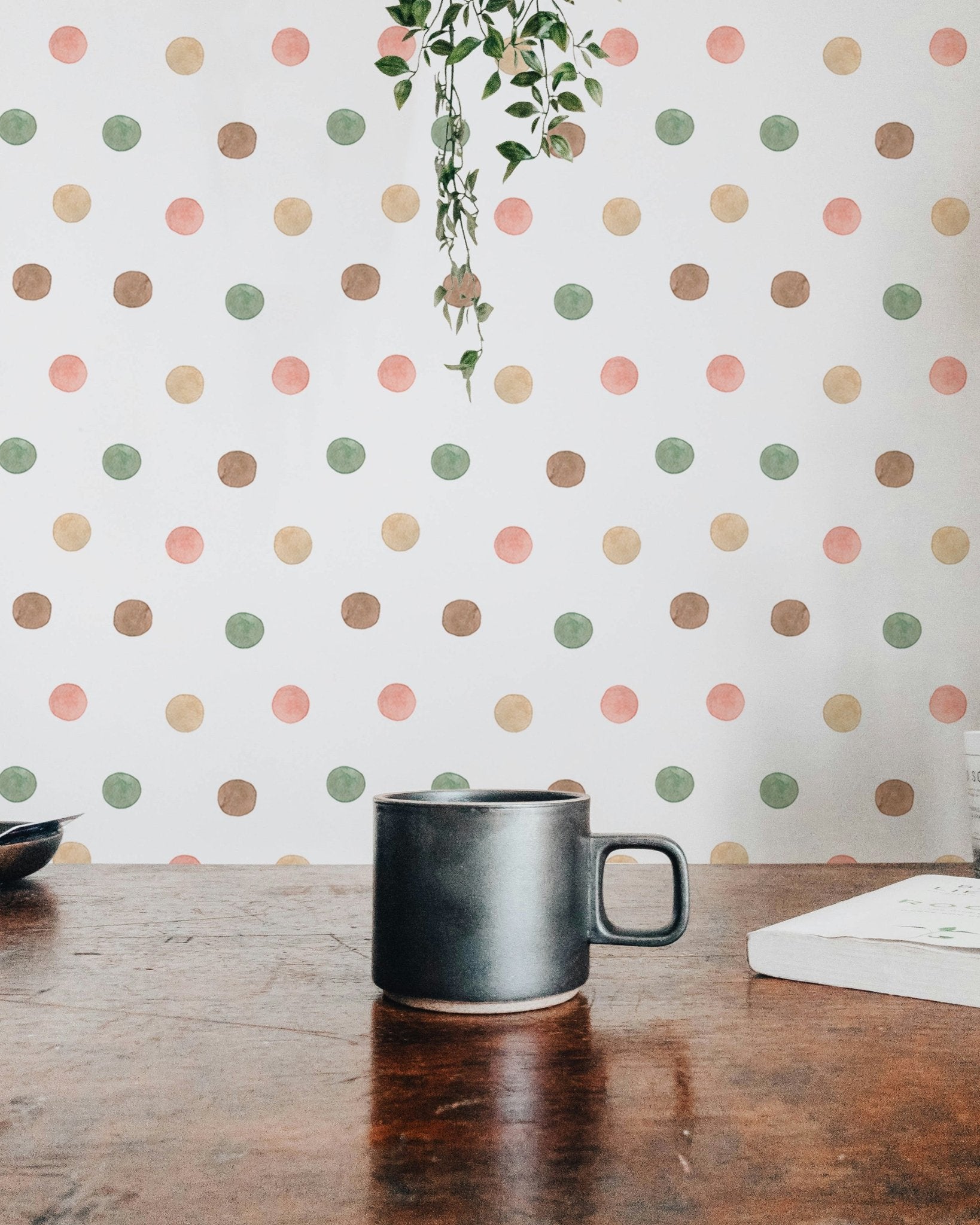 Coffee mug on a dark table with blurred polka dot wallpaper in the background.