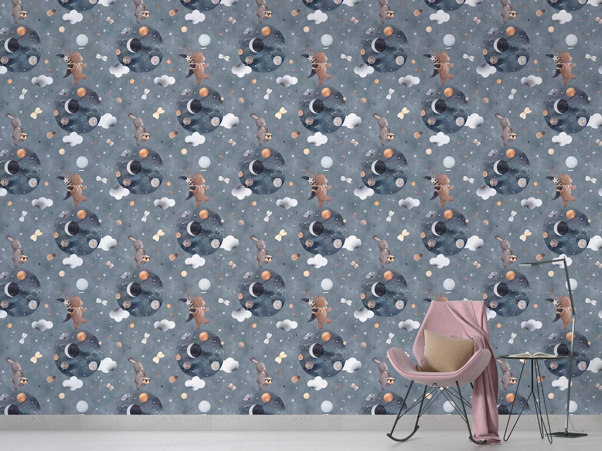 Grey and blue space themed wallpaper behind a pink rocking chair in a playroom.