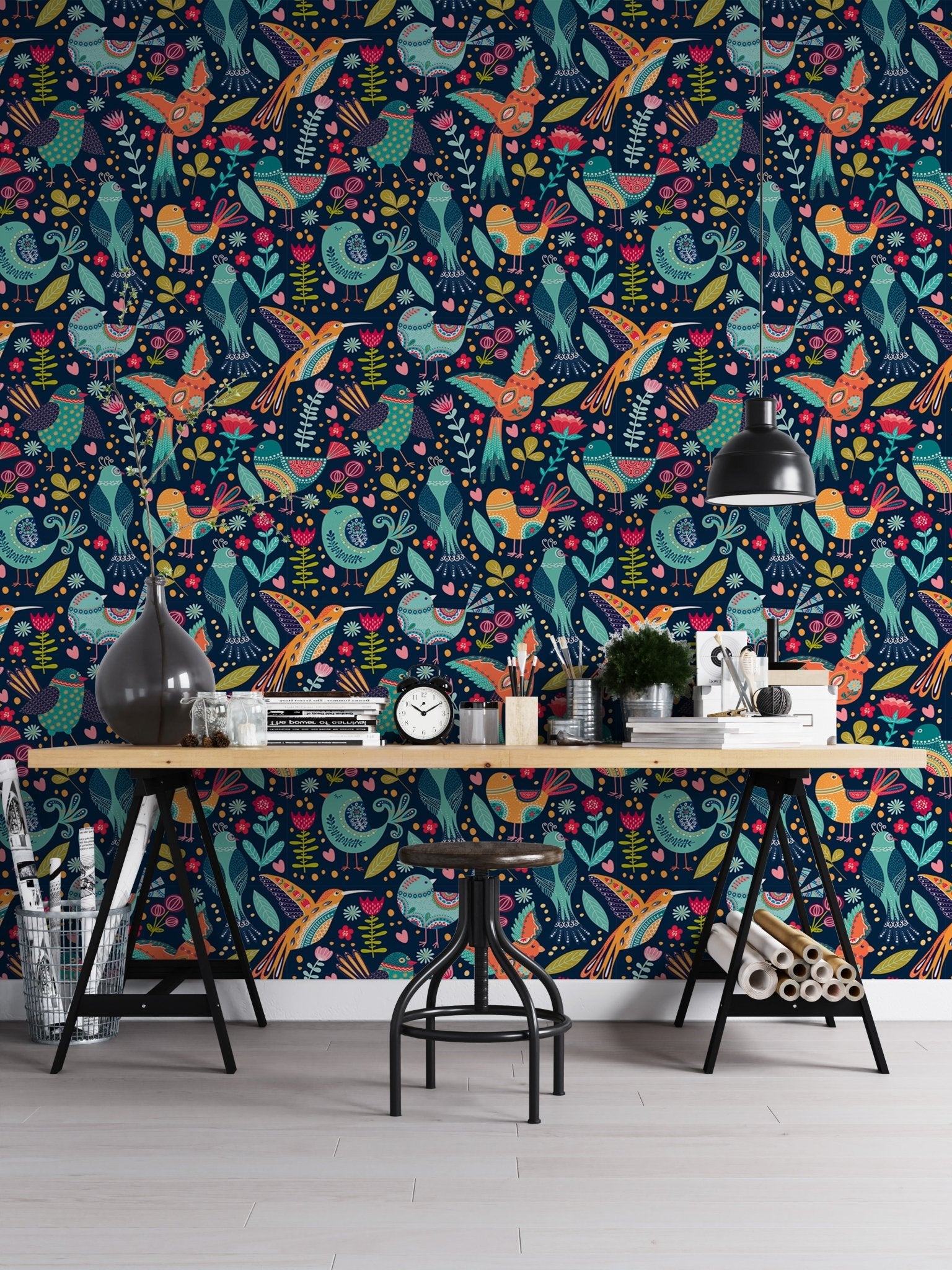 Vibrant floral and bird wallpaper in a modern workspace with a metal desk.