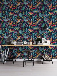 Vibrant floral and bird wallpaper in a modern workspace with a metal desk.