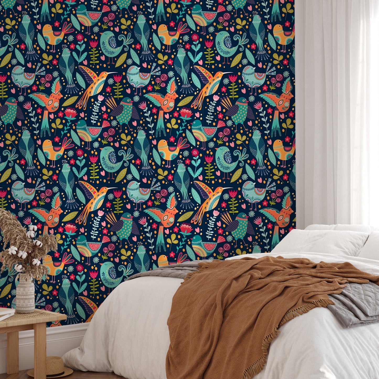 Folk art bird wallpaper in a bedroom with a brown knit throw blanket.