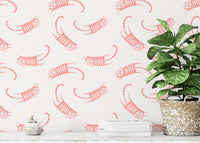 Seamless cat pattern wallpaper in a bright room with a large leafy floor plant.