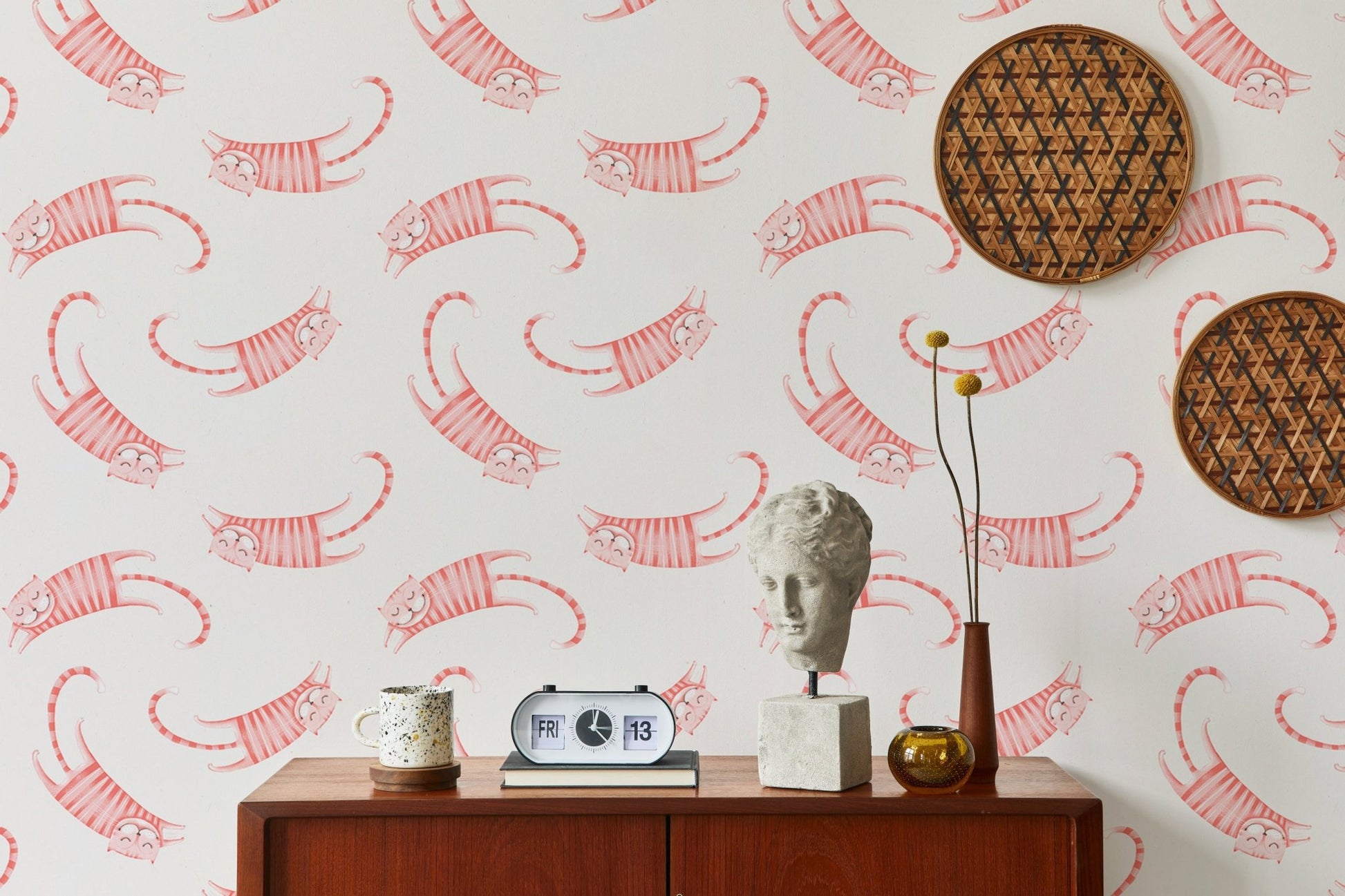 Living room wallpaper with pink striped cats and circular woven wall art.