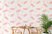 Dining space with wooden chairs and pink cat pattern wallpaper background.