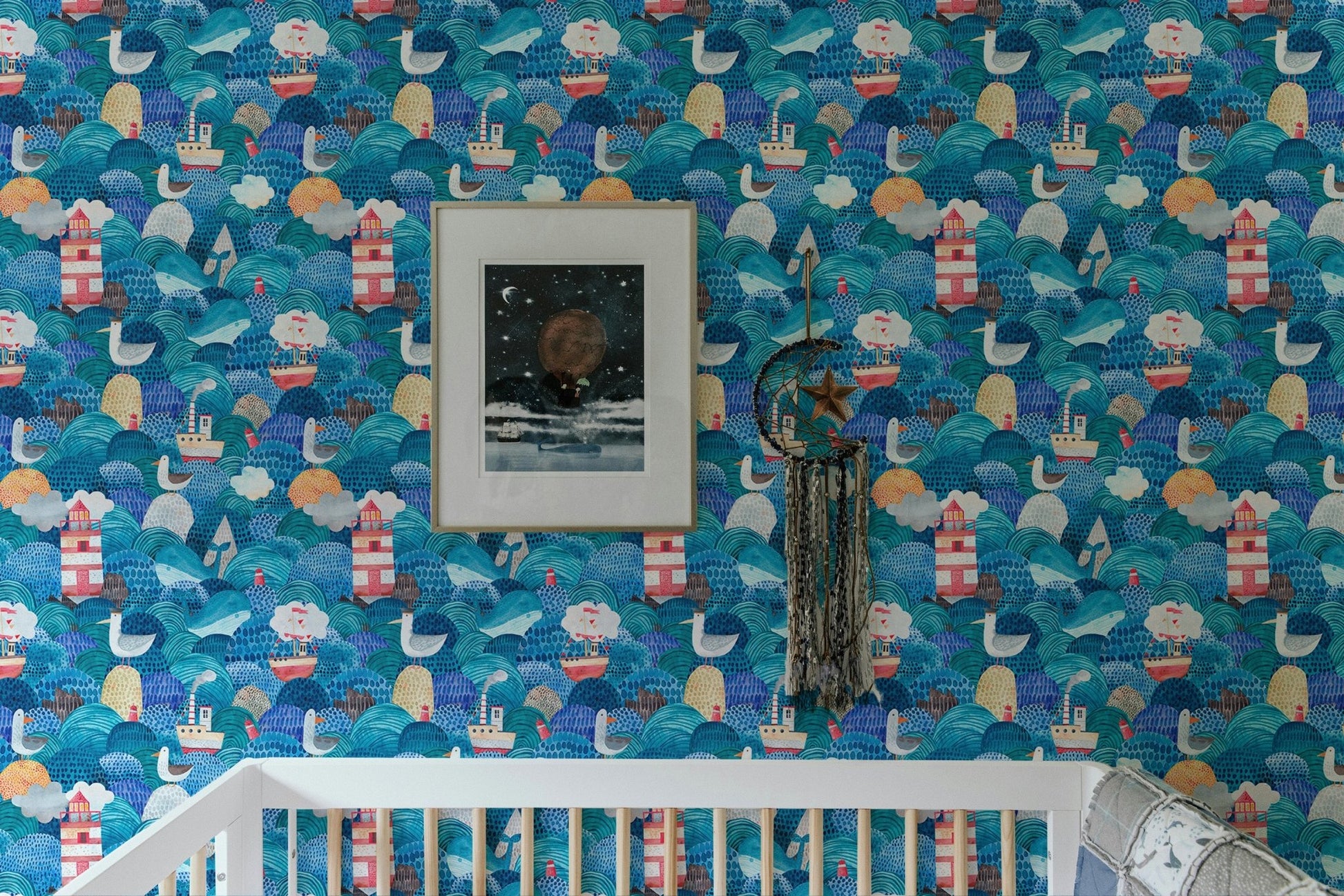 Nursery room crib placed in front of watercolor sea waves wallpaper.