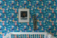 Nursery room crib placed in front of watercolor sea waves wallpaper.