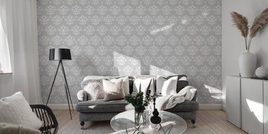 Grey damask wallpaper in a living room with a grey sofa and large windows.