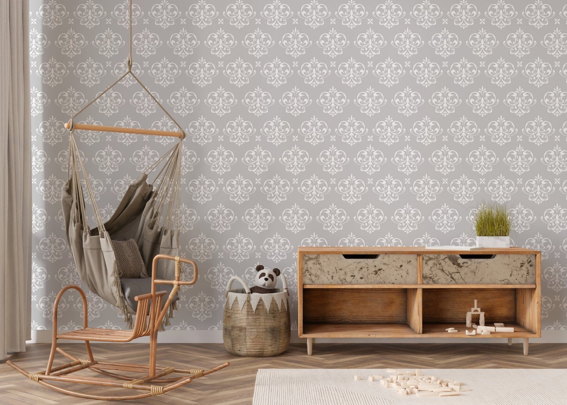 Vintage damask wallpaper in a nursery area with a wooden sideboard and swing chair.