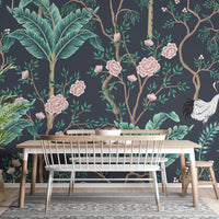 Botanical wall mural featuring teal leaves and pink blossoms behind a dining table.