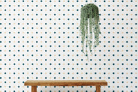 White wallpaper with small blue and yellow dots behind a wooden bench.