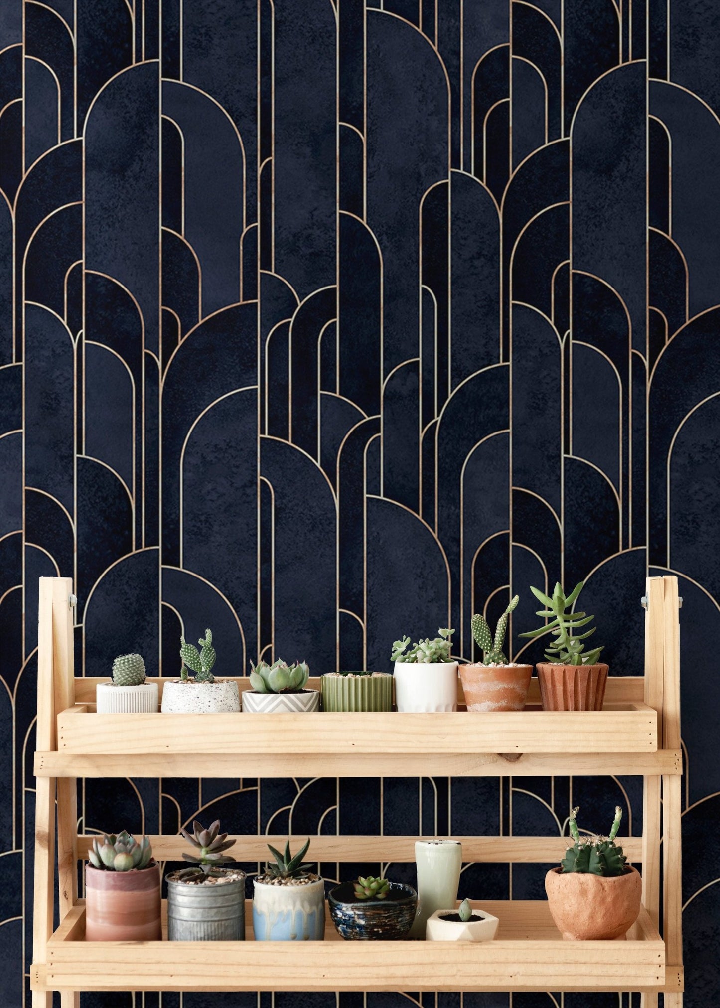 Patterned deco wallpaper behind a wooden plant stand with small succulents.