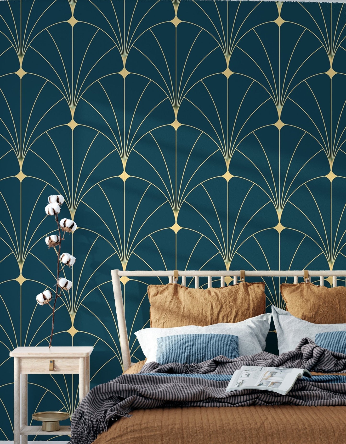 Gold on blue geometric wallpaper behind a bed with light blue linens.