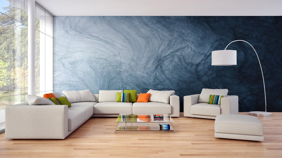 Blue fluid texture wallpaper behind a white sectional sofa in a living area.