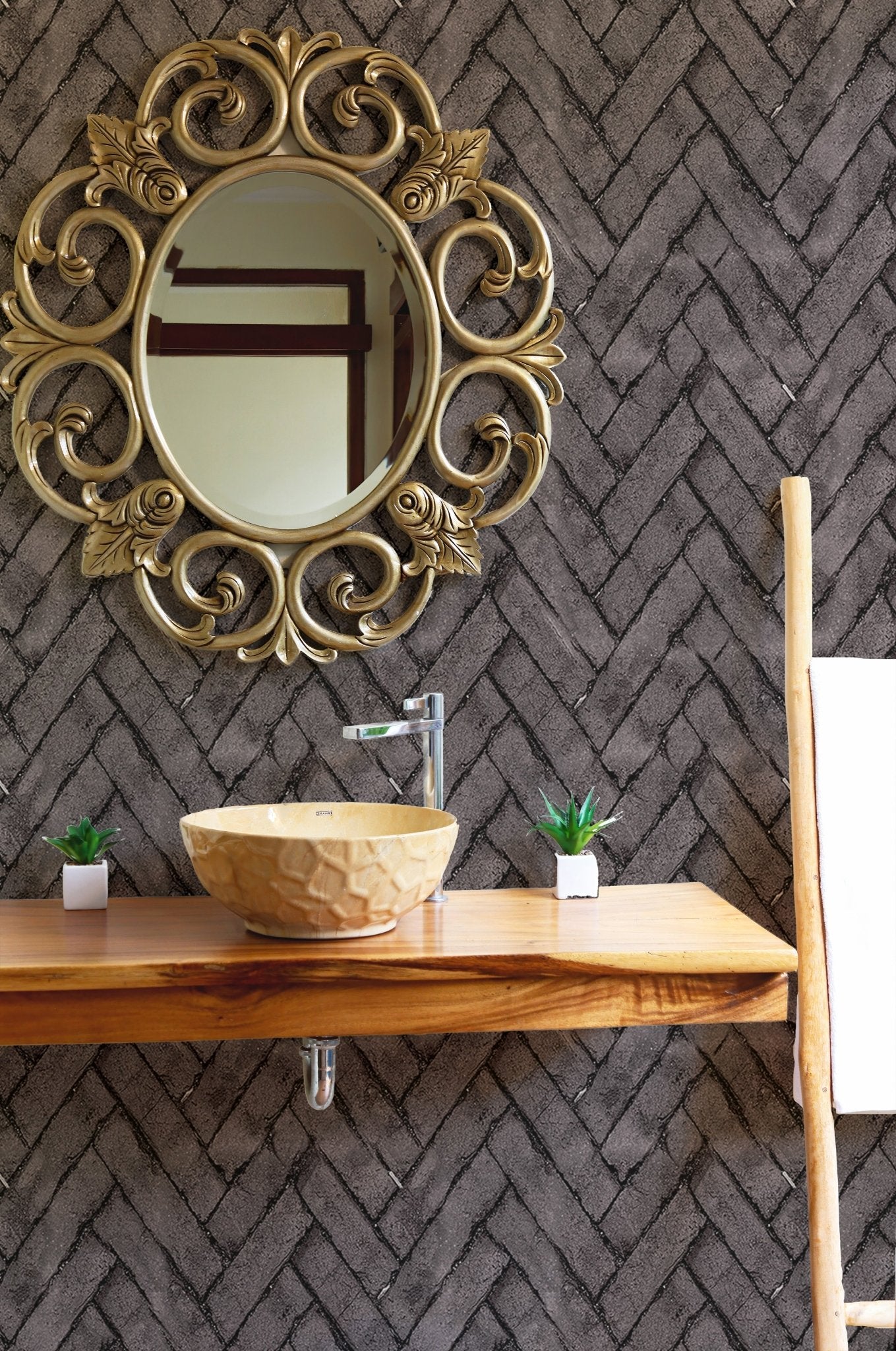 Bathroom vanity area with dark brown brick repeat pattern wallpaper and gold mirror.