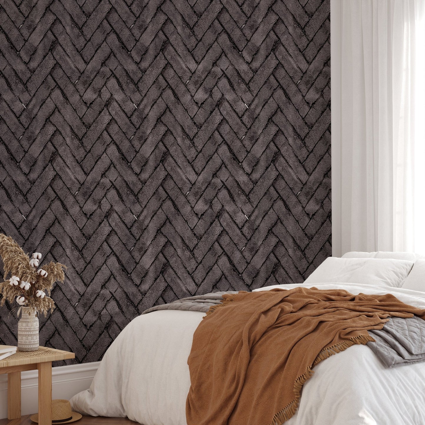 Bedroom wallpaper with dark brown herringbone brick pattern behind a white bed.