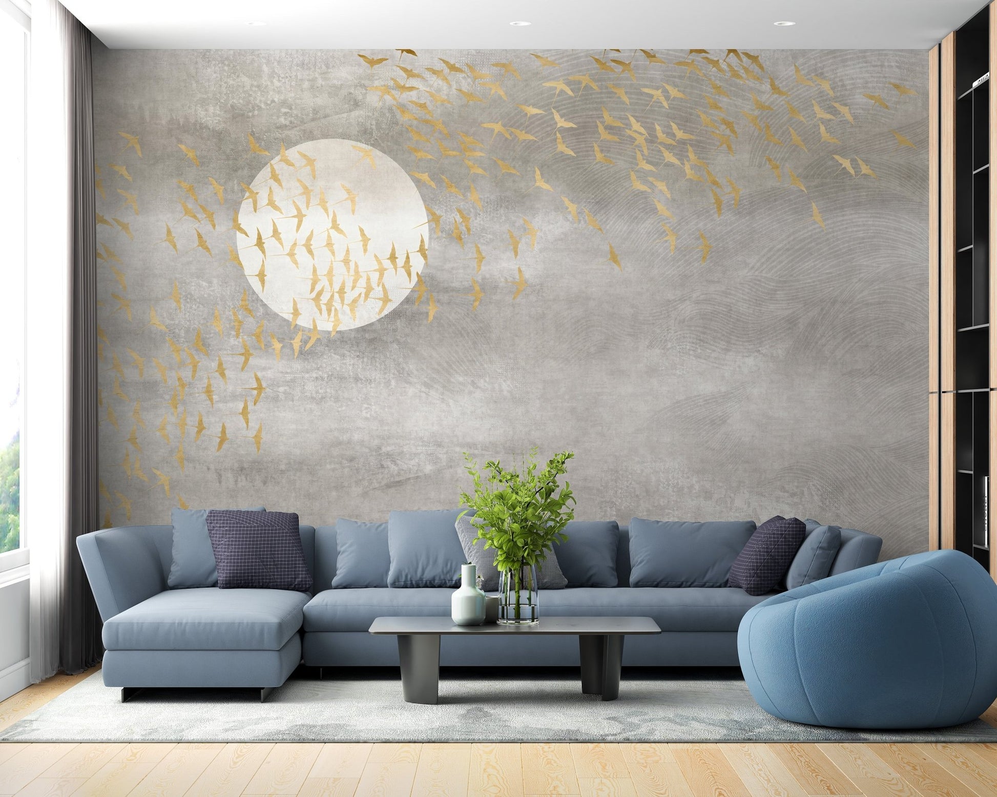 Blue corner sofa with golden bird silhouette wall mural on a grey backdrop.