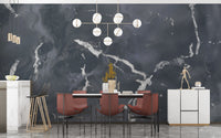 Contemporary dining space with gold accents and dark gray marble mural.