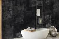 Matte black headline print wall mural in a contemporary bathroom.