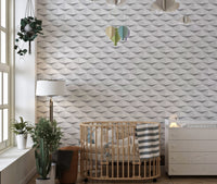 Geometric abstract wallpaper in a nursery room featuring a wooden crib and green plants.