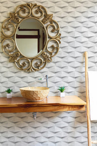Ornate gold mirror on a white textured wallpaper wall in a bathroom.