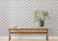 Modern wooden bench with a green plant against a white geometric wallpaper.
