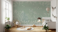 Nature inspired green wall mural with white illustrations for a child’s bedroom.